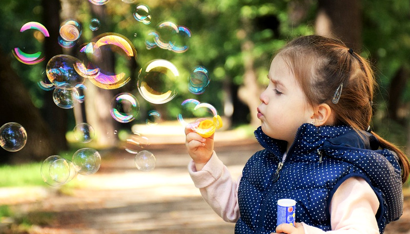 Little kid blowing bubbles