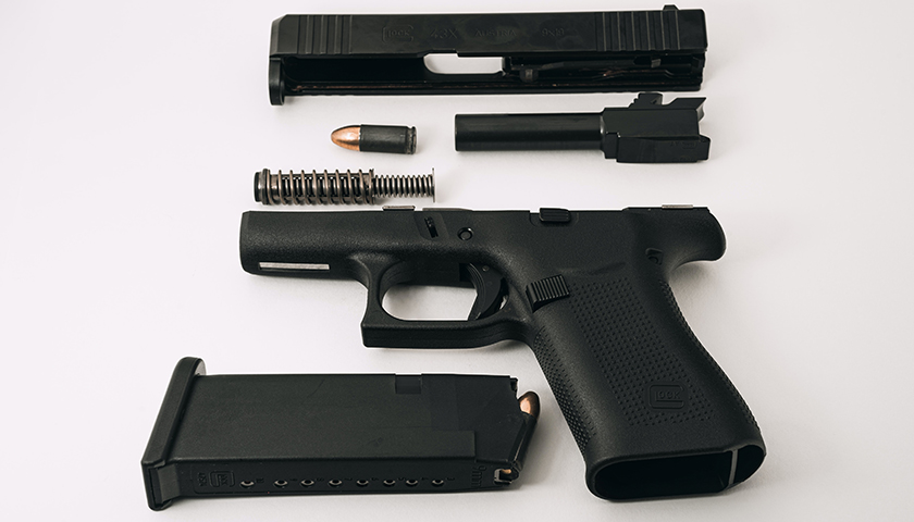 Disassembled Glock G43X (barrel, guide rod, and slide removed), loaded magazine, and 9mm round.