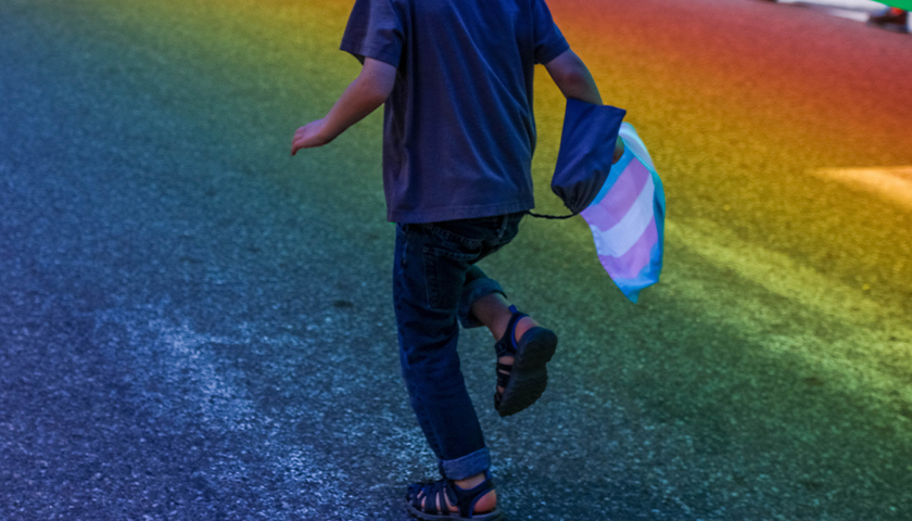 child running with trans flag