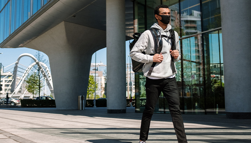 College student walking on campus, wearing mask