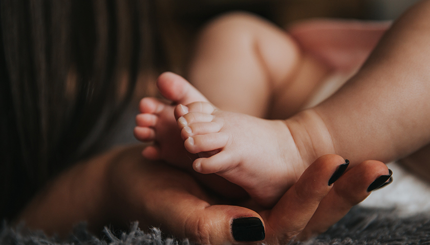 Infants feet in woman's hand