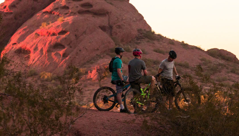 Three people on bikes in Arizona during sundown