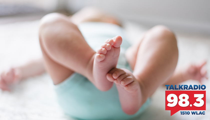 Baby laying on a bed, close up of feet