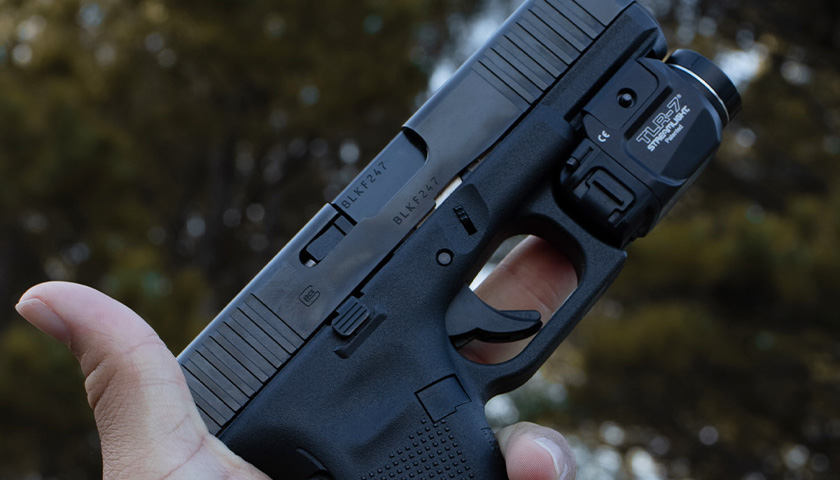 Person holding a Glock 9mm in left hand