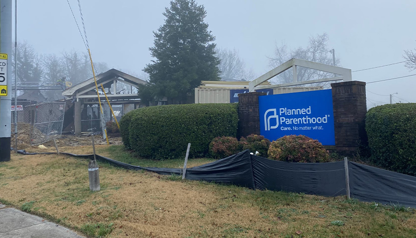 Burned down building with Planned Parenthood sign in front