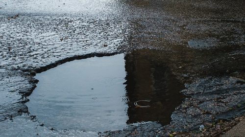 closeup of a pothole on a rainy day