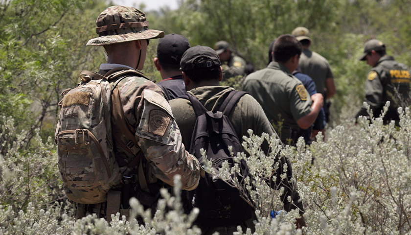Four illegal aliens apprehended in dense brush by members of the U.S. Border Patrol Search, Trauma, and Rescue (BORSTAR) team are led to awaiting vehicles near Eagle Pass, Texas, June 19, 2019. As Border Patrol agents are tasked to conduct intake and processing of the recent surge in migrant arrivals at the border, members of BORSTAR have been assisting in pursuing illegal aliens afield. CBP photo by Glenn Fawcett