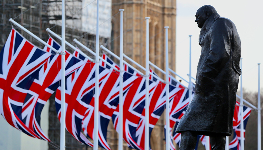 statue of Winston Churchill with British flags in front of him