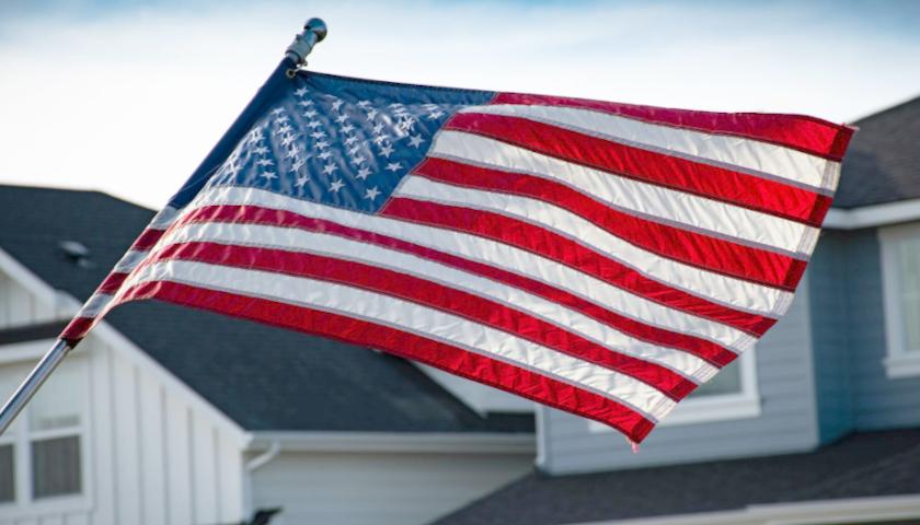 American flag waving in front of house