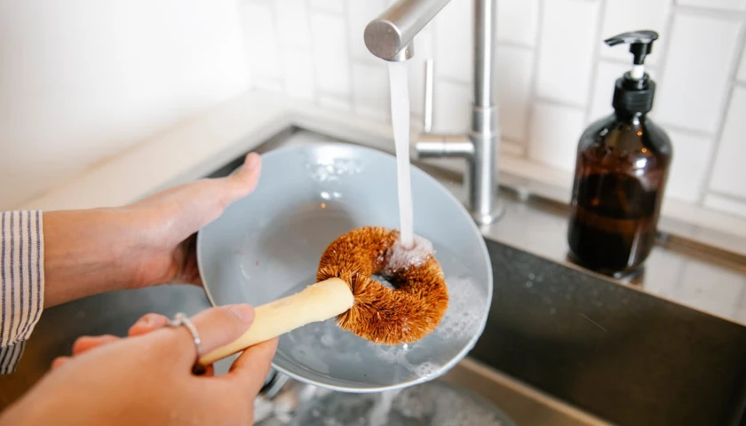 Cleaning dishes in kitchen sink